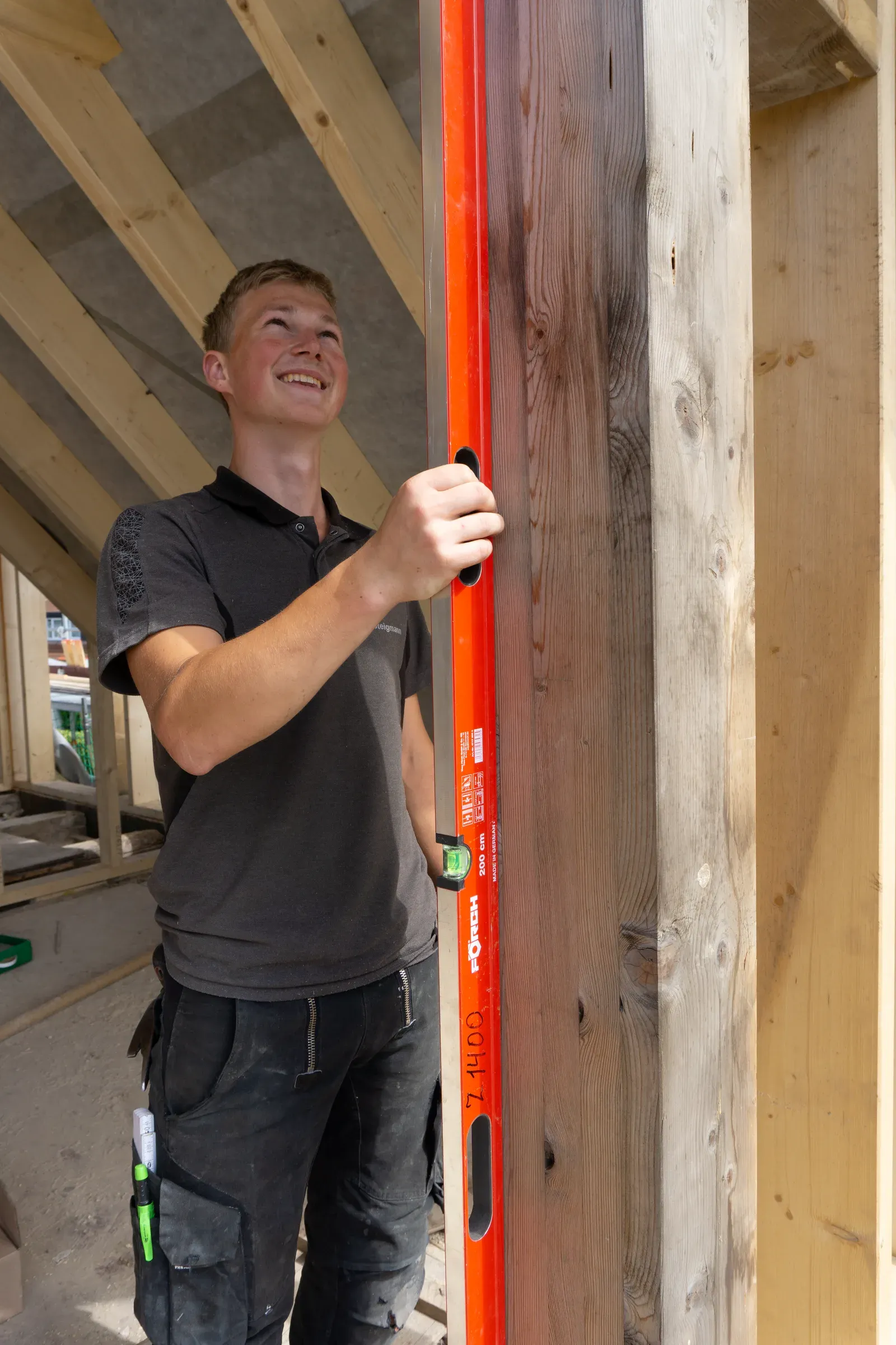 Junger SSR Handwerker prüft präzise mit der Wasserwaage